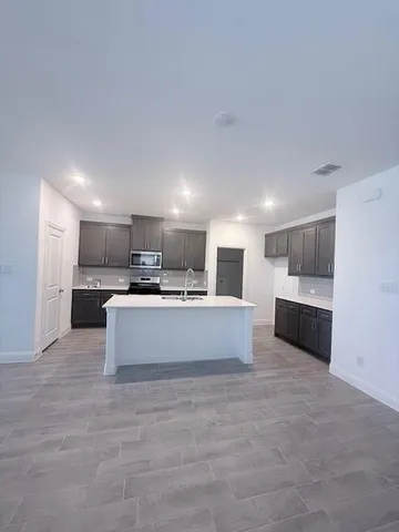 a large white kitchen with kitchen island a sink a stove and a refrigerator