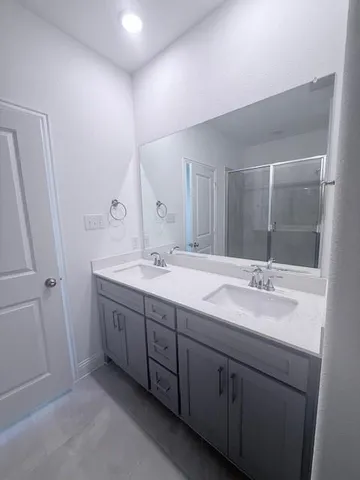 a bathroom with double sink and a mirror