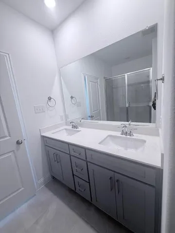 a bathroom with double sink and a mirror