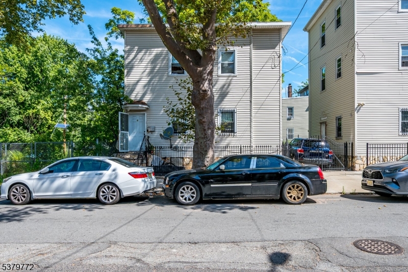 369 21st Street Irvington, NJ 07111 - Photo 15 of 16 a car parked in front of a white house