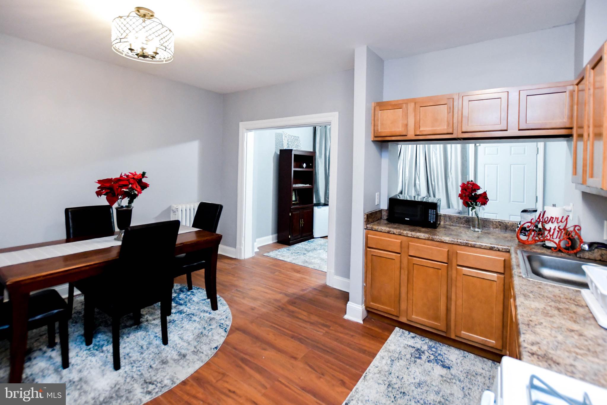 1430 W Street Southeast Washington, DC 20020 - Photo 14 of 41 a kitchen with stainless steel appliances granite countertop a sink dishwasher and a dining table with cabinets