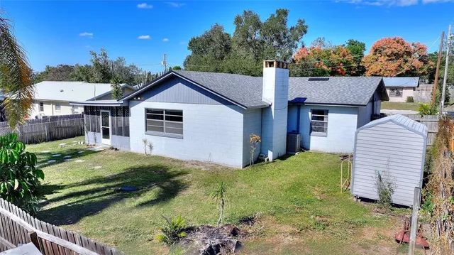 a view of a house with backyard and a tree