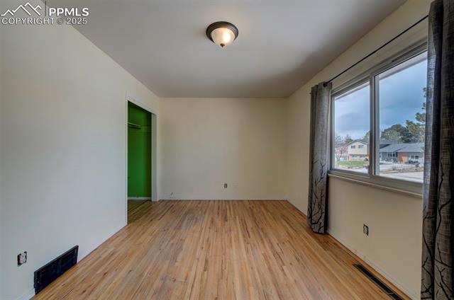6773 Dale Road Colorado Springs, CO 80915 - Photo 23 of 45 Empty room with light wood-style flooring and visible vents