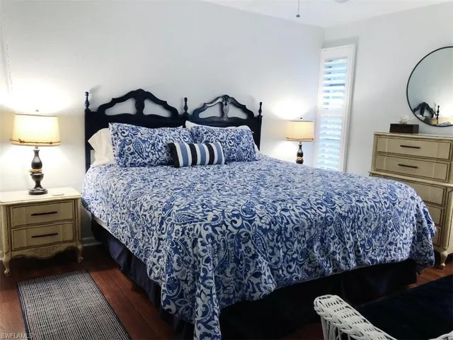 a bedroom with a bed and dresser with mirror