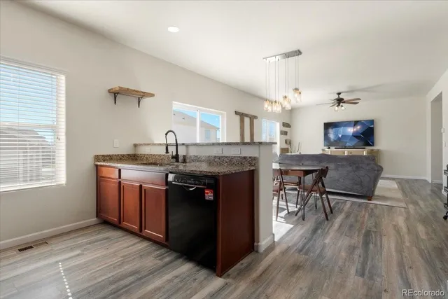a kitchen with granite countertop a sink cabinets and wooden floor