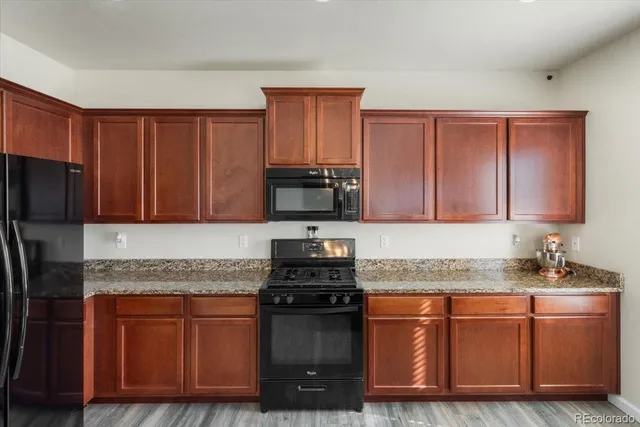 a kitchen with granite countertop stainless steel appliances and wooden cabinets
