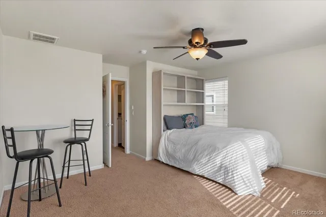 a bedroom with a bed a chandelier and a window