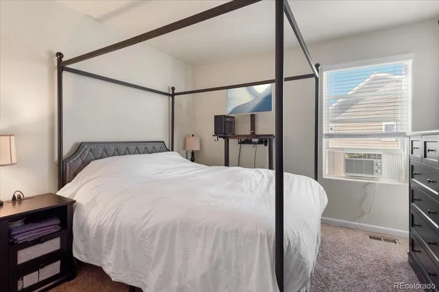 a large bed sitting in a bedroom next to a window