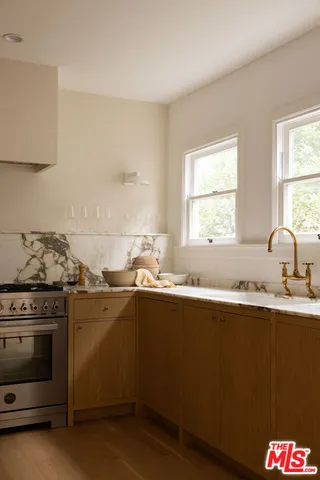 a kitchen with granite countertop a sink stove and cabinets