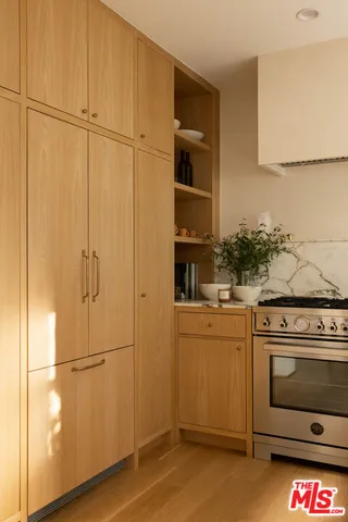 a kitchen with stainless steel appliances wooden floor and cabinets