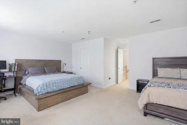 a spacious bedroom with a bed and a lamp