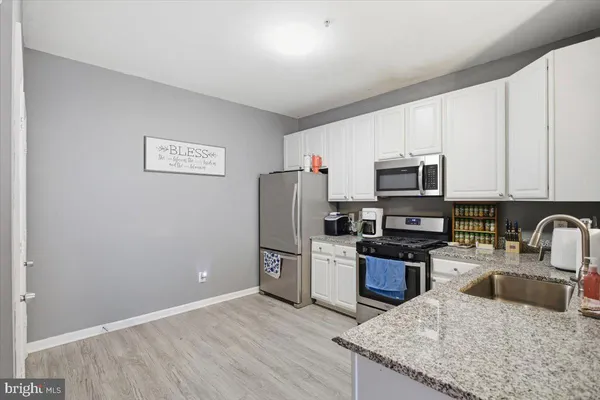 a kitchen with granite countertop a refrigerator sink and stove