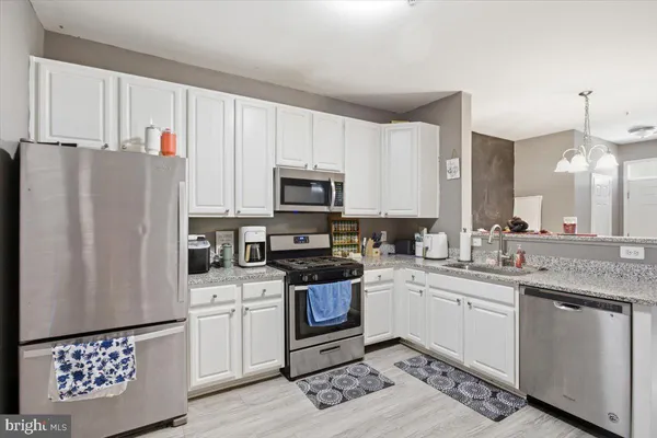 a kitchen with a sink a refrigerator a microwave and cabinets