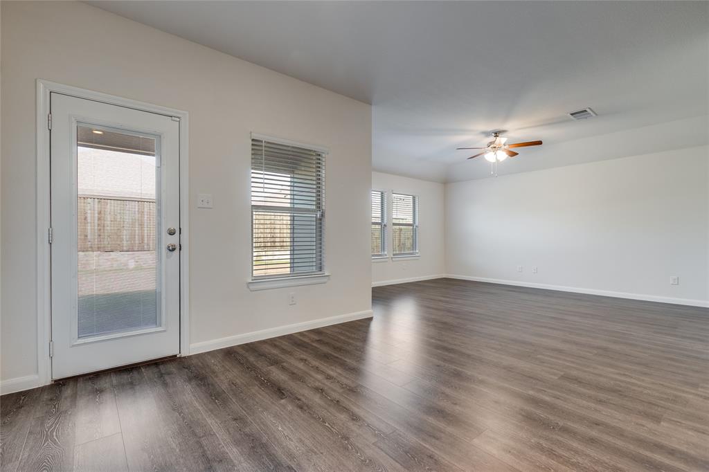 504 Stampede Lane Princeton, TX 75407 - Photo 7 of 13 a view of an empty room with wooden floor and a window