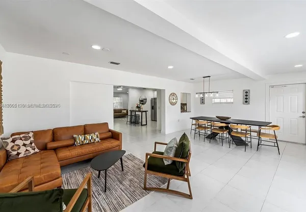 a view of livingroom and dining room with furniture wooden floor a rug and a chandelier