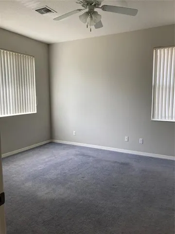 an empty room with a window and a ceiling fan
