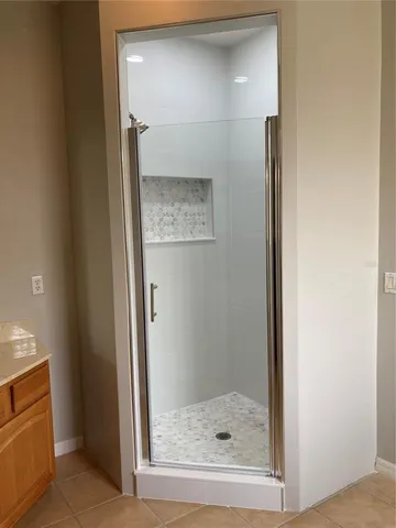 a bathroom with a glass shower door and a sink