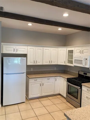 a kitchen with granite countertop a refrigerator and a sink