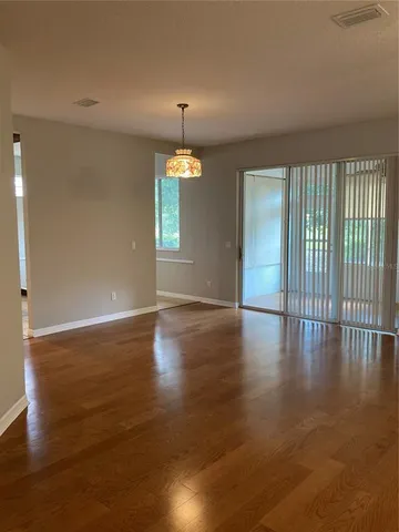 an empty room with wooden floor and window