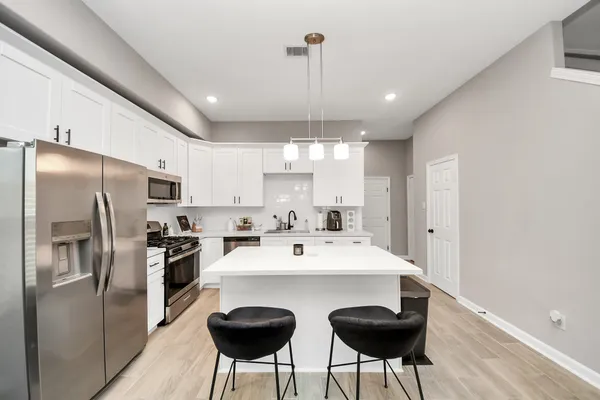 a kitchen with a sink a counter top space stainless steel appliances and cabinets