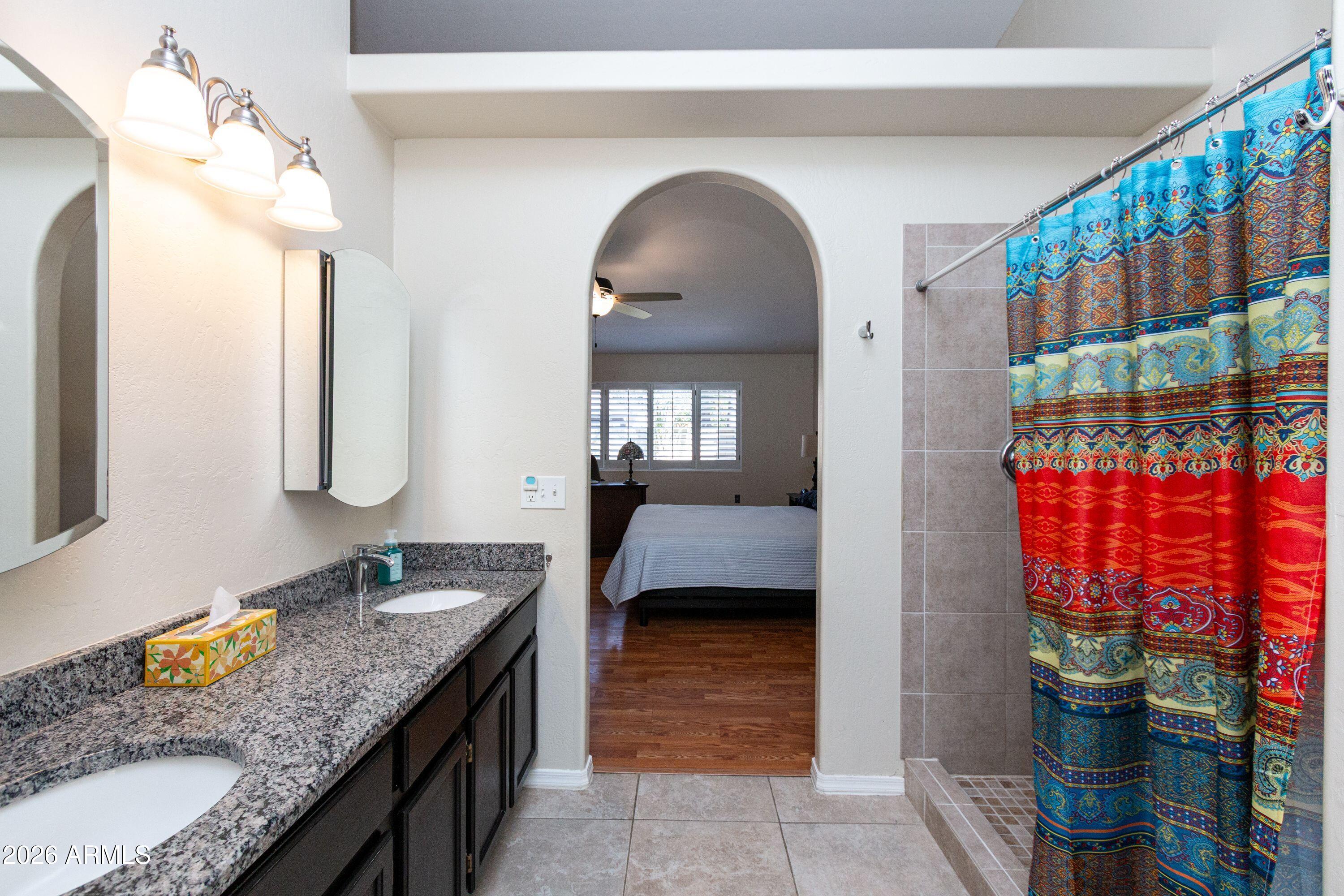 450 East Merrill Avenue Gilbert, AZ 85234 - Photo 16 of 26 a en suite bathroom with a granite countertop sink and a mirror