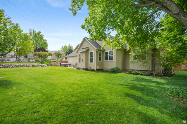 357 South 320 W Street Lindon, UT 84042 - Photo 30 of 41 Expansive rear yard featuring a large grass area, mature trees, and a stone retaining wall