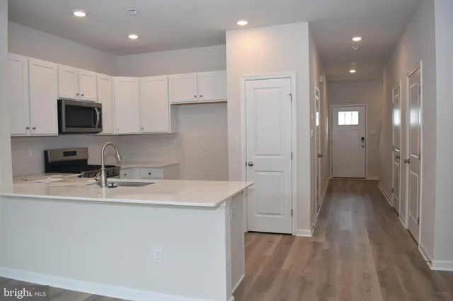 a kitchen with a sink a refrigerator and cabinets