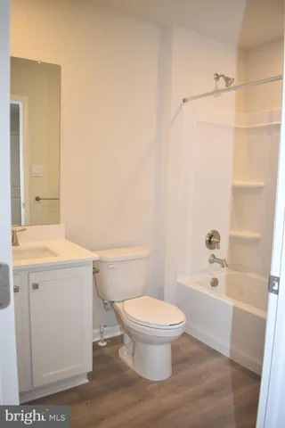 a white toilet sitting next to a bath tub