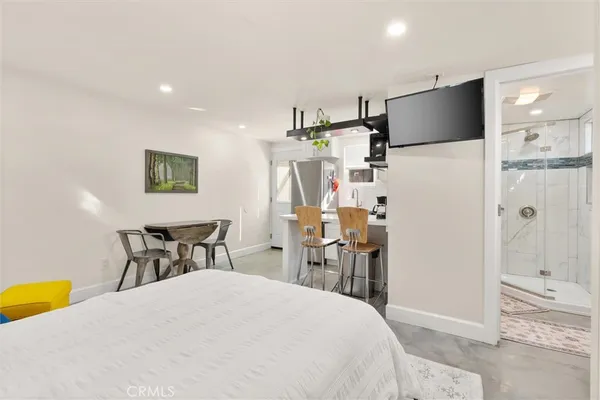 a bedroom with a bed a table and painting on the wall