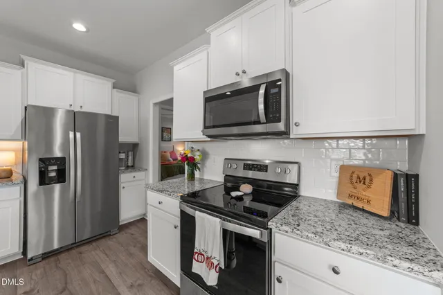 a kitchen with stainless steel appliances granite countertop a stove microwave refrigerator and sink