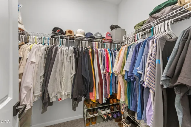 a view of walk in closet with clothes and shoes