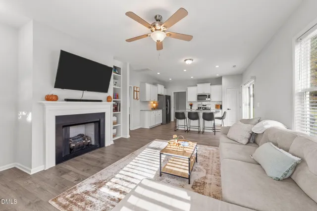 a living room with furniture a fireplace and a flat screen tv