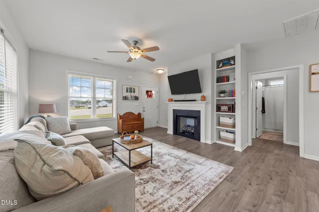a living room with furniture a fireplace and a flat screen tv