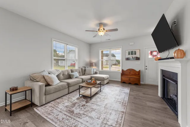a living room with furniture a fireplace and a flat screen tv