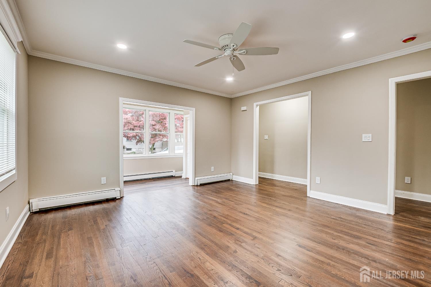 93 Player Avenue Edison, NJ 08817 - Photo 6 of 29 an empty room with wooden floor ceiling fan and windows