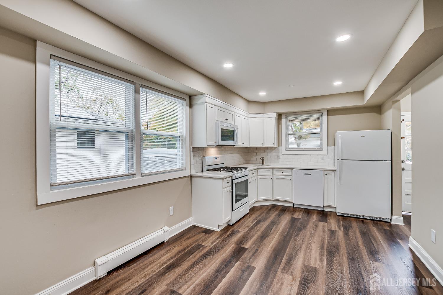 93 Player Avenue Edison, NJ 08817 - Photo 10 of 29 a kitchen with white cabinets and wooden floor