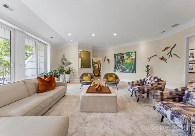 a living room with furniture kitchen view and a large window