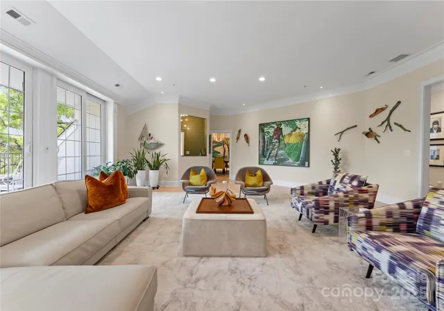 a living room with furniture kitchen view and a large window