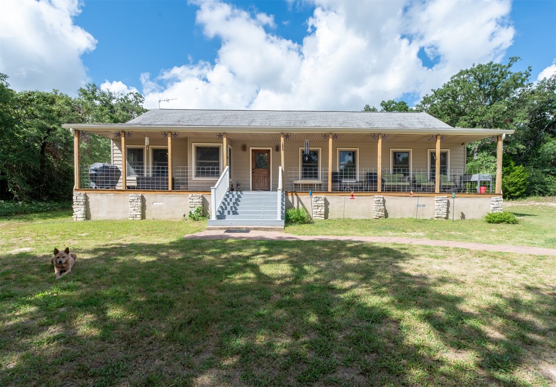 a front view of house with a garden and trees
