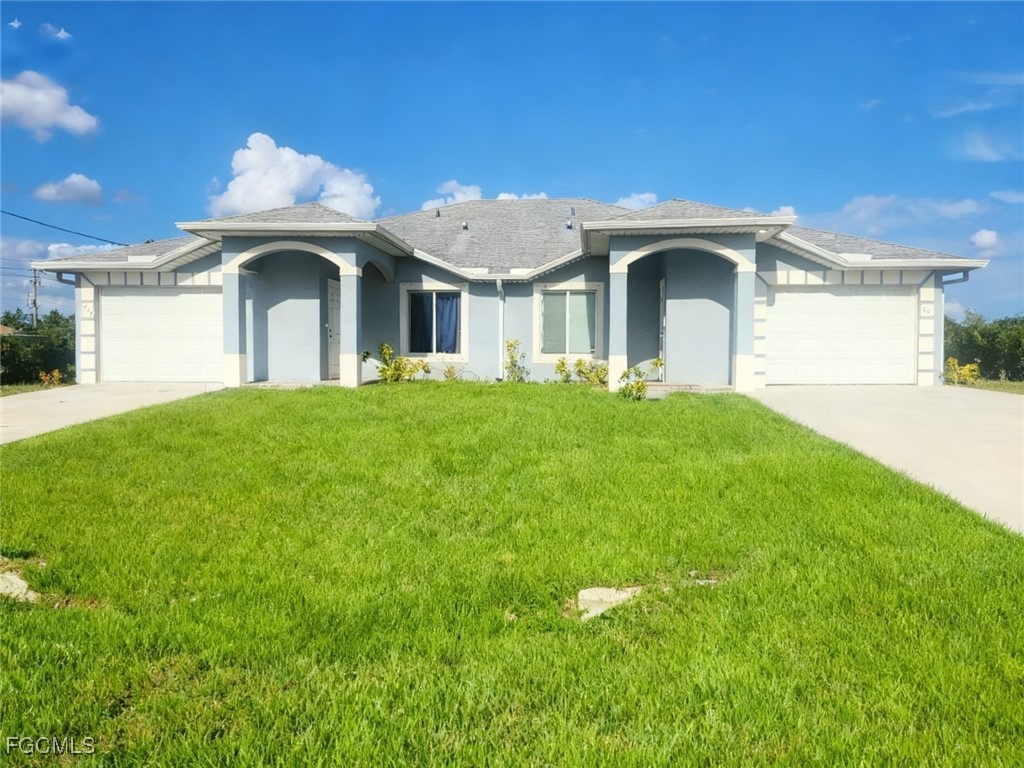a front view of a house with a yard and garage