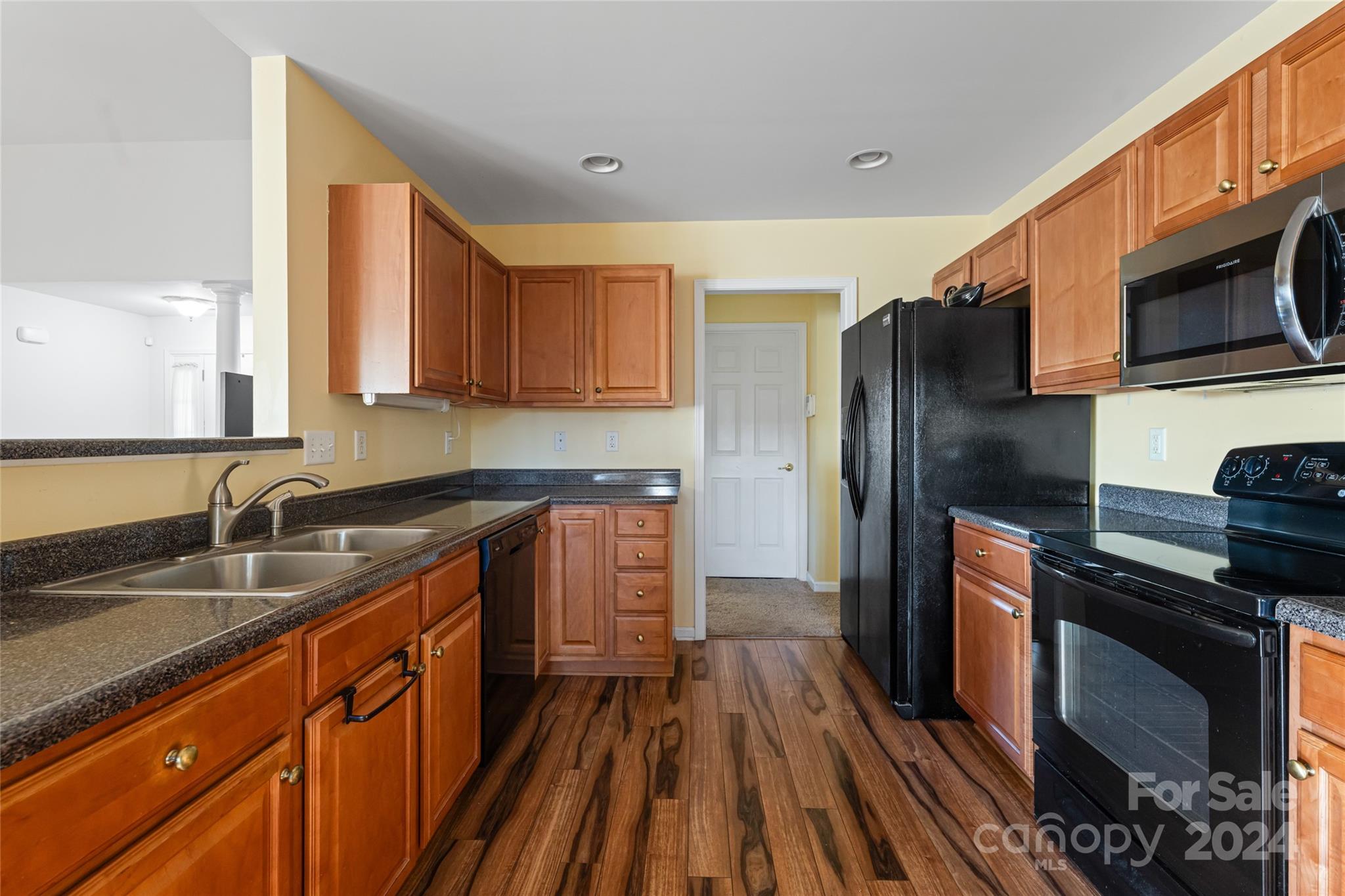 183 Lumber River Road Fletcher, NC 28732 - Photo 12 of 31 a kitchen with stainless steel appliances granite countertop a refrigerator a sink dishwasher a stove and white countertops with wooden floor