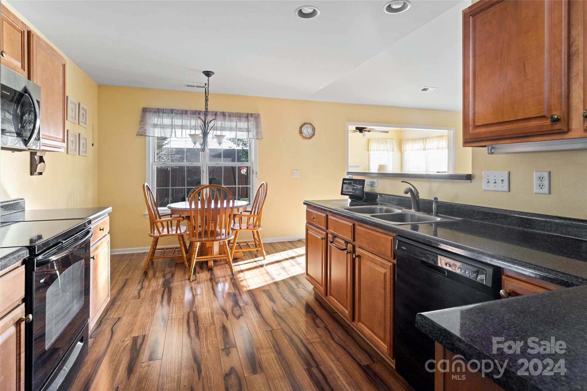 183 Lumber River Road Fletcher, NC 28732 - Photo 14 of 31 a kitchen with stainless steel appliances granite countertop a stove top oven a sink dishwasher a dining table and chairs with wooden floor