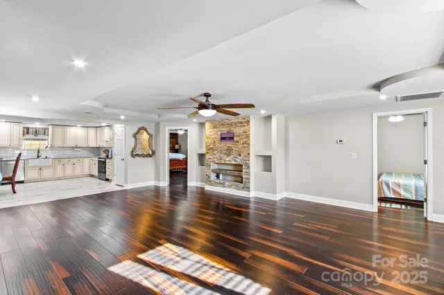 a kitchen with stainless steel appliances granite countertop a kitchen island hardwood floor sink stove dining table and chairs