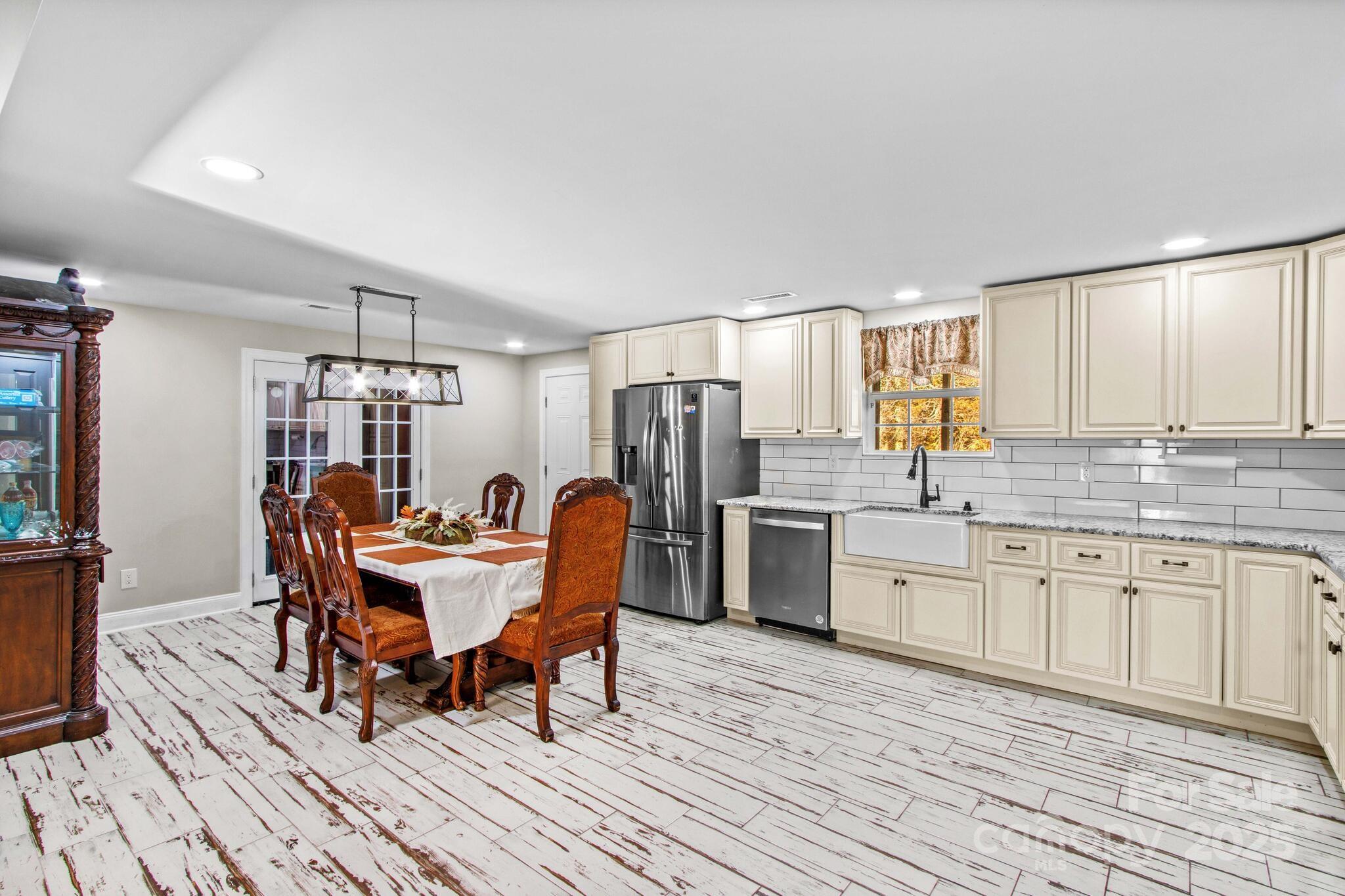 1493 Swicegood Road Linwood, NC 27299 - Photo 12 of 45 a kitchen with stainless steel appliances granite countertop a kitchen island hardwood floor sink stove dining table and chairs