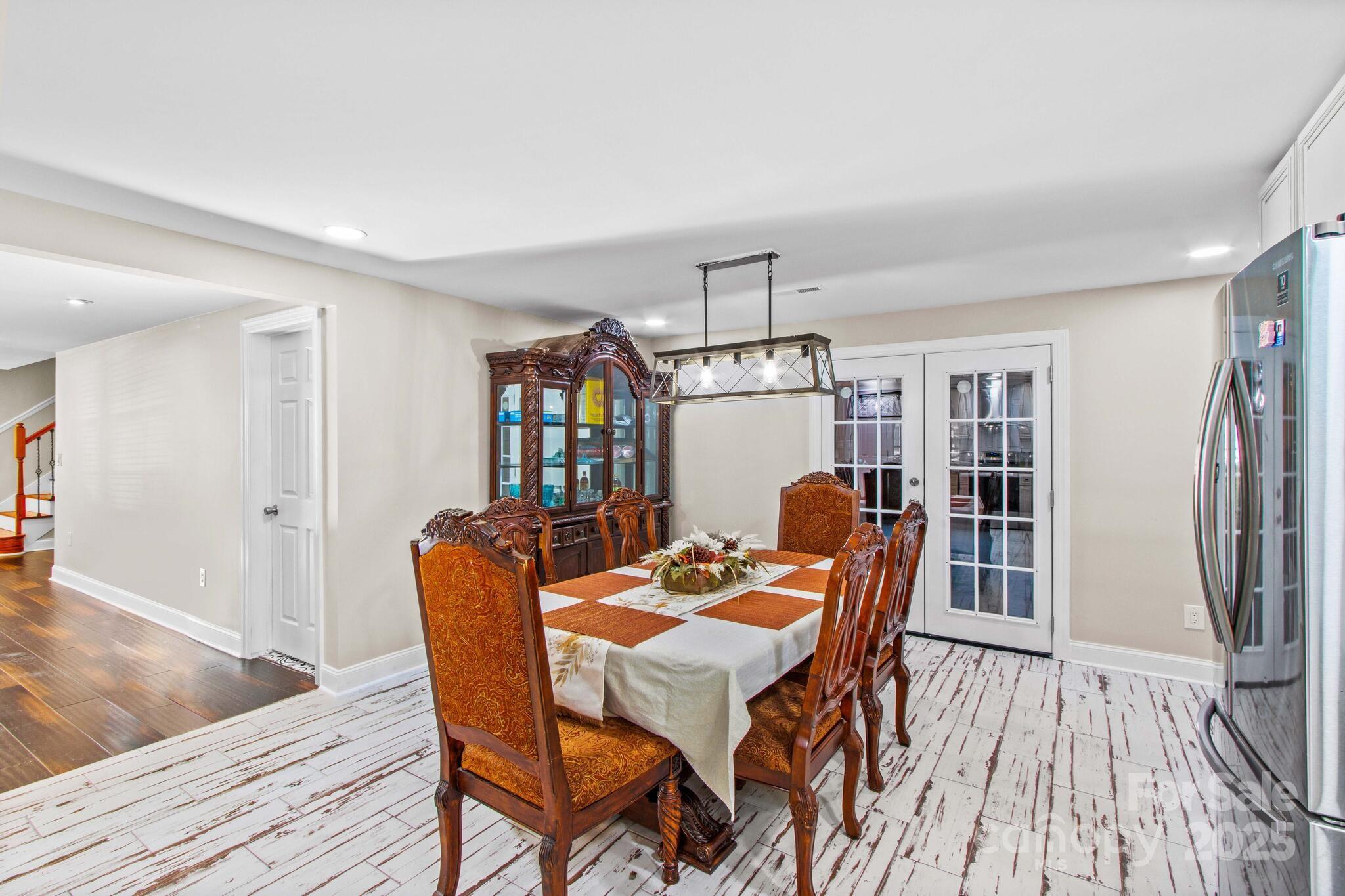 1493 Swicegood Road Linwood, NC 27299 - Photo 13 of 45 a dining room with furniture a chandelier and wooden floor
