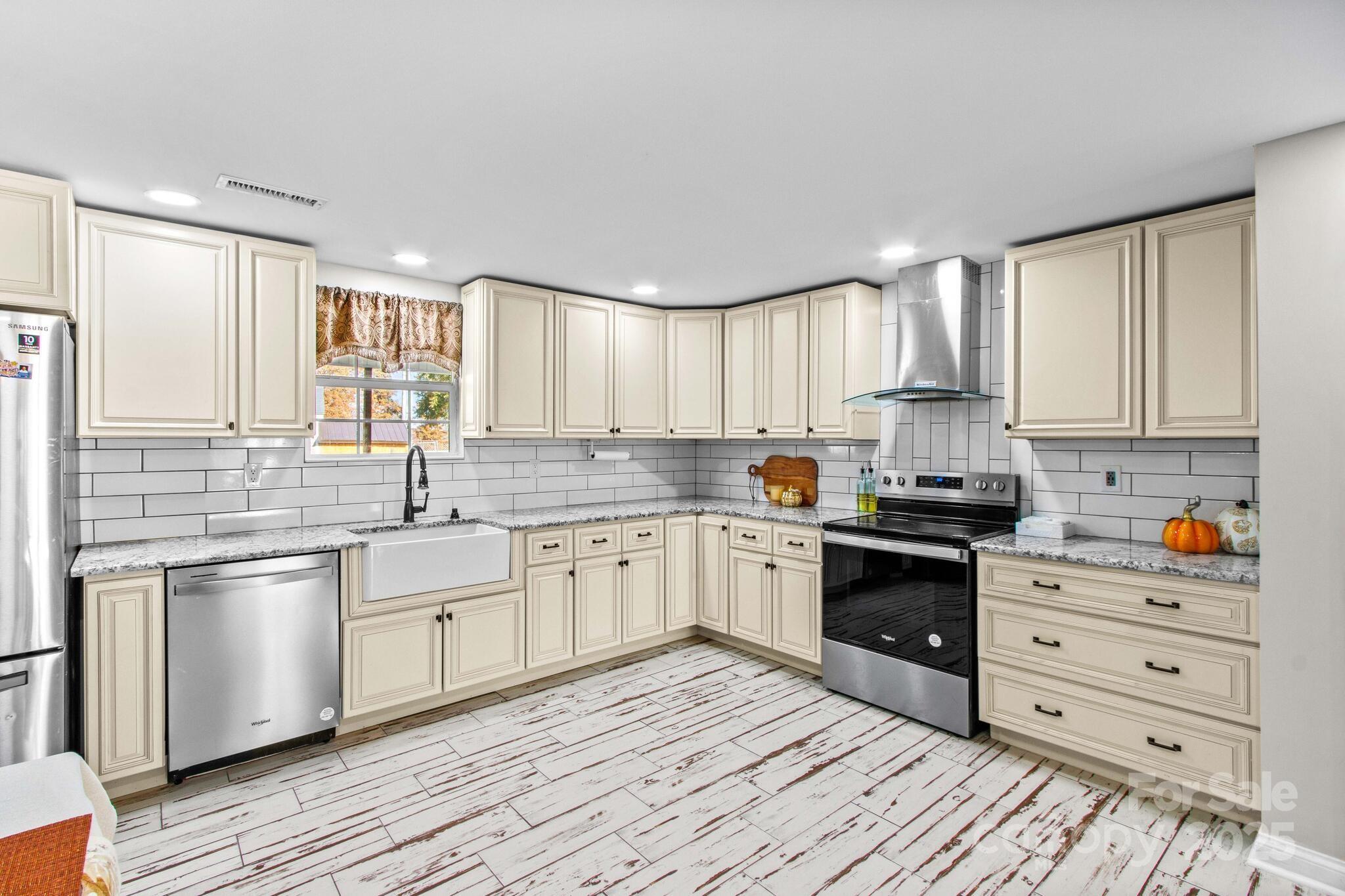 1493 Swicegood Road Linwood, NC 27299 - Photo 16 of 45 a kitchen with stainless steel appliances granite countertop a sink a stove cabinets and wooden floor