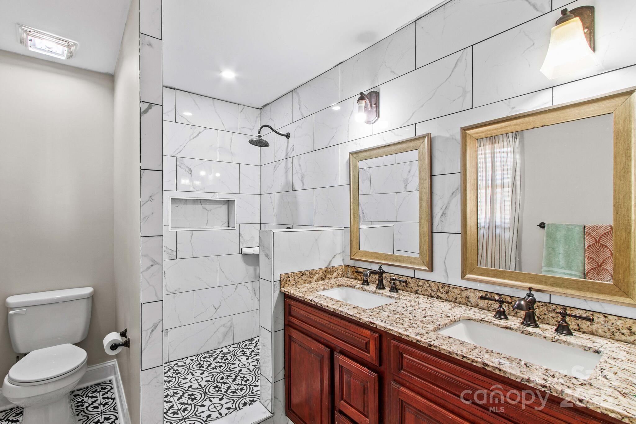 1493 Swicegood Road Linwood, NC 27299 - Photo 20 of 45 a bathroom with a granite countertop sink toilet and shower
