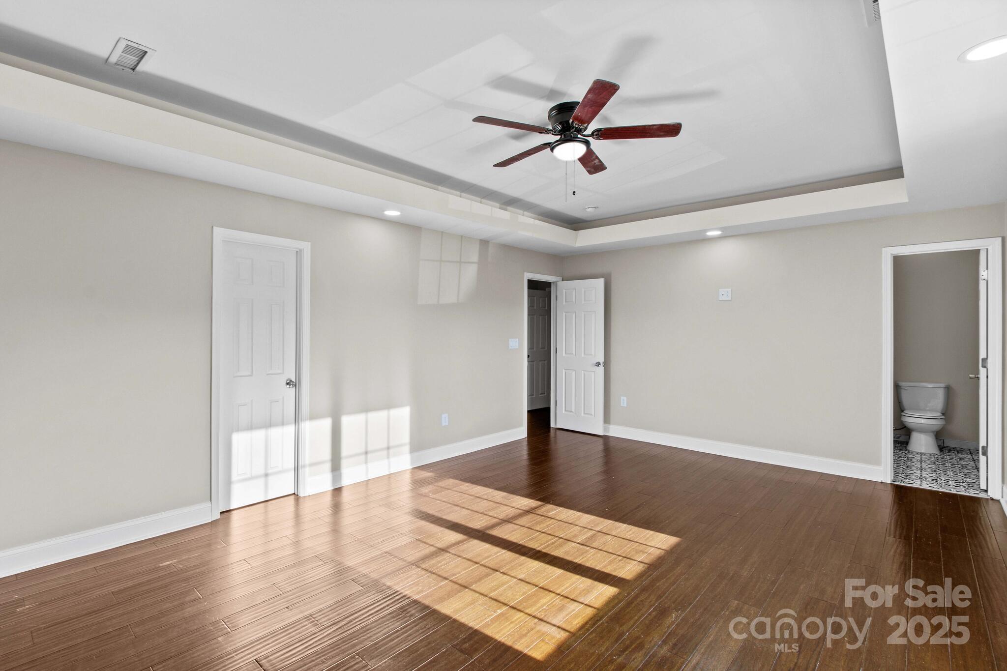 1493 Swicegood Road Linwood, NC 27299 - Photo 25 of 45 a view of an empty room with wooden floor and a ceiling fan
