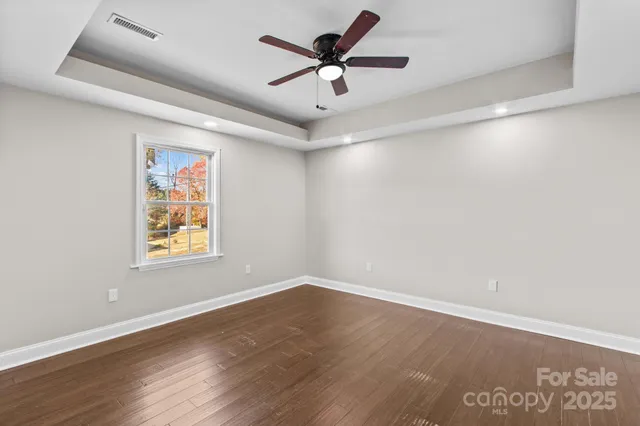 a view of a big room with wooden floor and windows