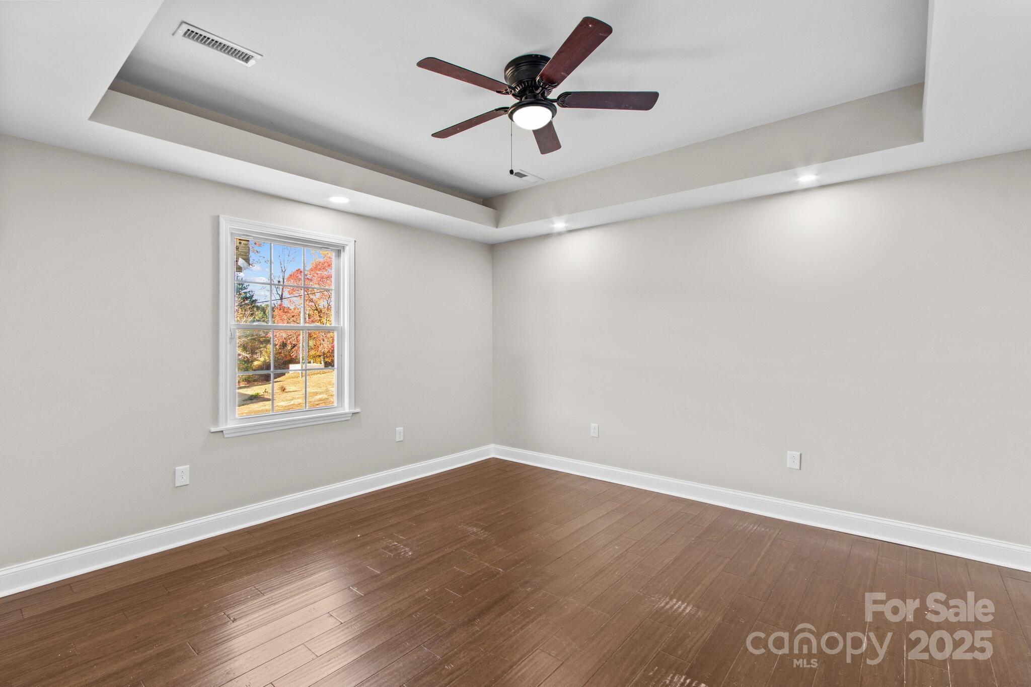 1493 Swicegood Road Linwood, NC 27299 - Photo 28 of 45 an empty room with wooden floor and ceiling fan